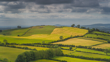 Obraz premium Ancient, neolithic burial chambers and stone circles of Loughcrew Cairns on the top of a hill, illuminated by sunlight, County Meath, Ireland