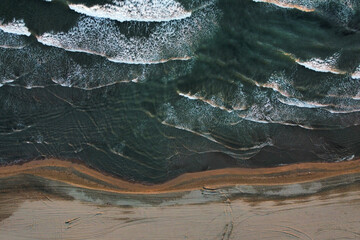 Sea waves roll on black sand, photo from a drone. Velika Plazha - Long Beach, Ulcinj, Montenegro