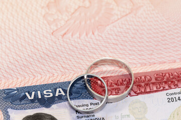 Closeup of wedding rings on usa visa as concept of marriage of convenience