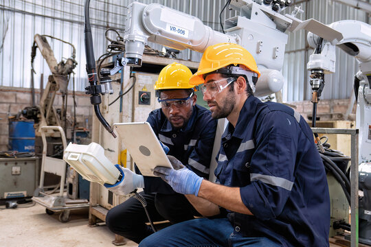 Maintenance engineer repair and programing robotic arm in factory Industry robot service shop