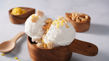 Coconut ice cream topped with roasted peanuts in a coconut shell