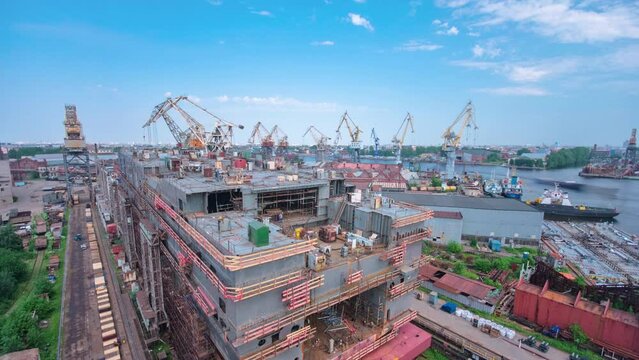The construction of a large ship on a shipyard timelapse with cranes. A fragment of the case in the workshop of the plant. Metal frame during assembly from above