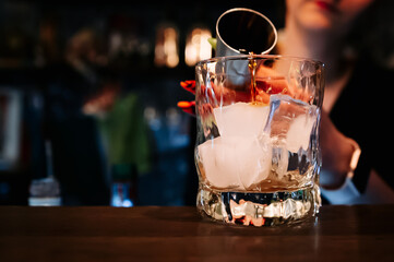 Bartender hand pouring whiskey on glass in bar