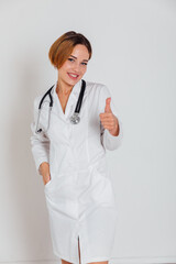 woman doctor in white coat with phonendoscope shows like