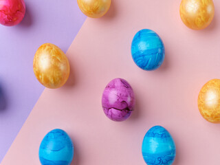 Flat lay with colored easter eggs on bright background. Creative template for festive content