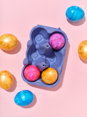 Top view layout with colored easter eggs on pink background. Creative template for festive content