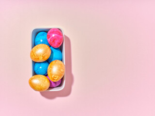 Top view layout with colored easter eggs on pink background. Creative template for festive content