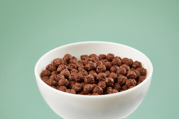 Bowl with chocolate balls. dry breakfast. crunchy corn balls with cocoa on color background. High quality 4k footage