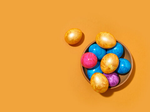 Creative layout with colored easter eggs on bright yellow background. A template for festive content