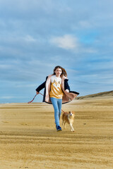 Pretty young girl playing with her young Border Collie on the beaches of South West France