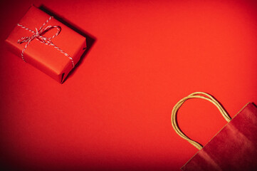 Red gift box and craft bag on a red background. The concept of holiday gifts.