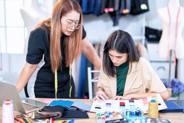 Fototapeta premium Senior fashion designer teamwork discuss teach learner final design share idea in shop lady tailor