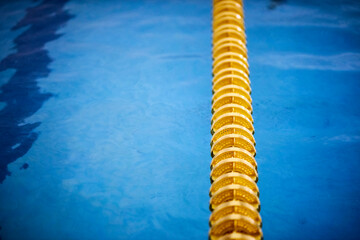 yellow buoys in the indoor pool. yellow dividing paths in the pool for professional swimming. close...