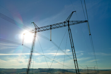 Fototapeta premium High voltage tower with electric power lines transfening electrical energy through cable wires