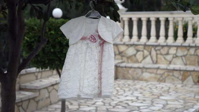 BAPTISM GIRLS DRESS WITH STONE AND COLUMNS IN BACKGROUND