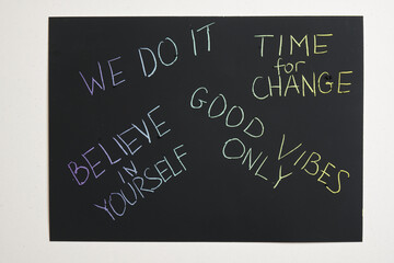 colored motivational slogans are scratched on on a black engraving board