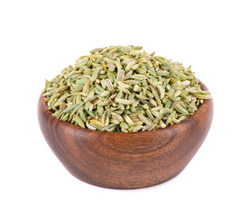 Fennel seeds in wooden bowl, isolated on white background. Green fennel grains. Spices and herbs.