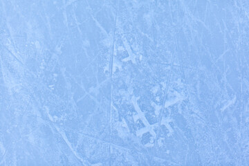 Empty ice rink with skate marks after the session outdoor. skating ice rink texture covered with snow in daylight. Close up of blue ice rink floor, copy space