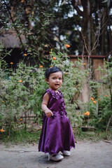 South asian little adorable cute girl on her first birthday, baby girl in princess dress, kid playing outside 