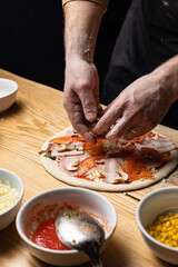 the chef prepares delicious pizza in the restaurant. Close-up
