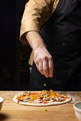 the chef prepares delicious pizza in the restaurant. Close-up
