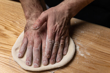 the chef prepares delicious pizza in the restaurant. Close-up
