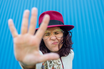 Cheerful designer woman showing her own designs on the street on blue background