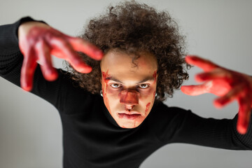 african american man with wounded face and bloody hands looking at camera isolated on grey