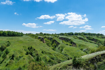 View ravine covered with greenery. Landscape valley with geological faults. Earthen mountains and...