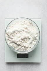 Flour being weighed on a digital scale, flour for baking being weighed