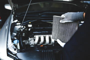 Car air conditioner system maintenance, Hand mechanic holding car air filter to check for clean...