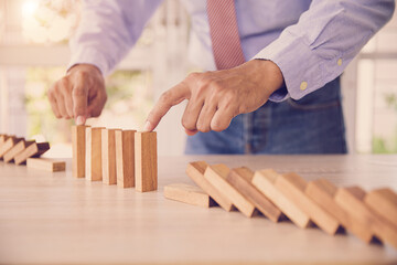 Close-up hand prevent wooden block not falling domino concepts of financial risk management and strategic planning and business challenge plan or safety insurance.