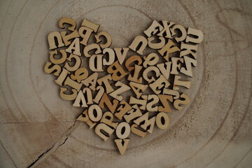 Top view of square wooden tiles with the English alphabet scattered on a wooden background with space for text. The concept of thinking development, grammar