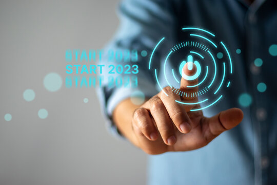 Businessman touching start button in 2023