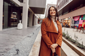 Obraz premium Young beautiful woman in brown coat walking on the autumn street.