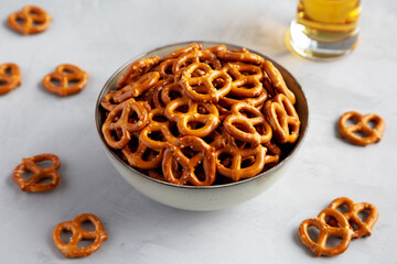 Mini Pretzels with Salt in a Bowl on a gray background, side view.