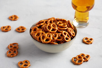 Mini Pretzels with Salt in a Bowl on a gray background, side view.