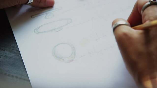 Goldsmith designing ring making sketch on paper