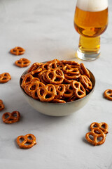 Mini Pretzels with Salt in a Bowl on a gray background, side view.