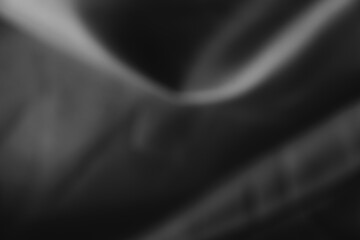 Dark black and gray blurred background has a little abstract light