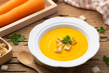 Tasty creamy Carrot Soup with croutons in bowl on wooden background,Healthy food