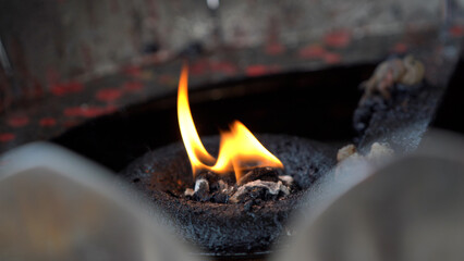 Candle burning and floating on oil sink.