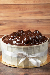 Profiterole cake. Cake with profiteroles surrounded by white chocolate on a wood background. close up