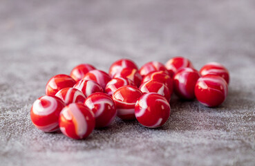Glass colored marble balls , glass balls isolated on gray background . Children's play equipment.