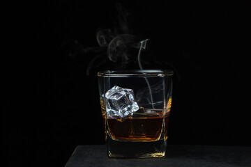 Glass of whiskey with ice on a black background. alcoholic drink