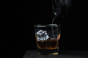 Glass of whiskey with ice on a black background. alcoholic drink