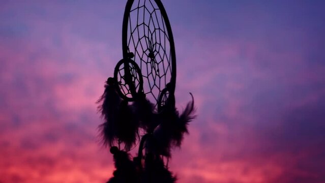 dreamcatcher in wind over beautiful cloudy sunset sunrise sky
