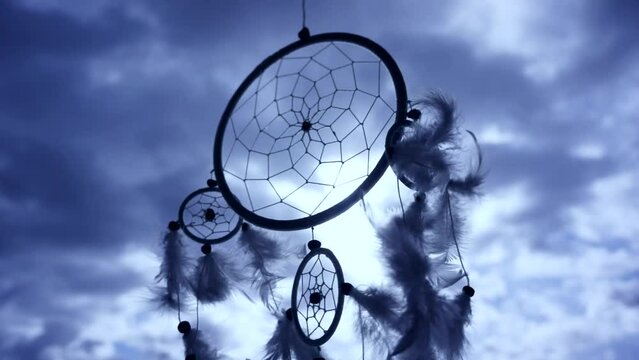 dreamcatcher in wind over beautiful cloudy sunset sunrise sky