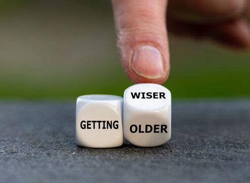 Hand turns dice and changes the expression 'getting older' to 'getting wiser'.