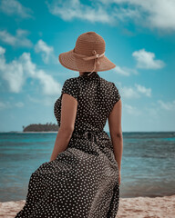 brunette woman with hat on the beach in a sunny day